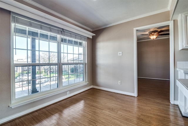 spare room with ceiling fan, ornamental molding, and light wood-type flooring