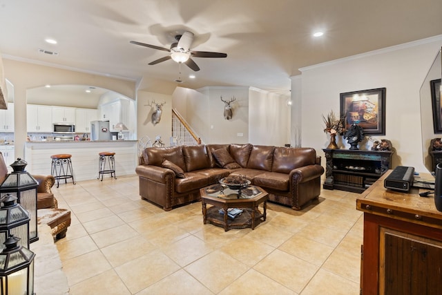 living room with ceiling fan, crown molding, and light tile patterned flooring