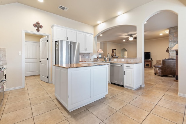 kitchen with a peninsula, visible vents, appliances with stainless steel finishes, and white cabinets