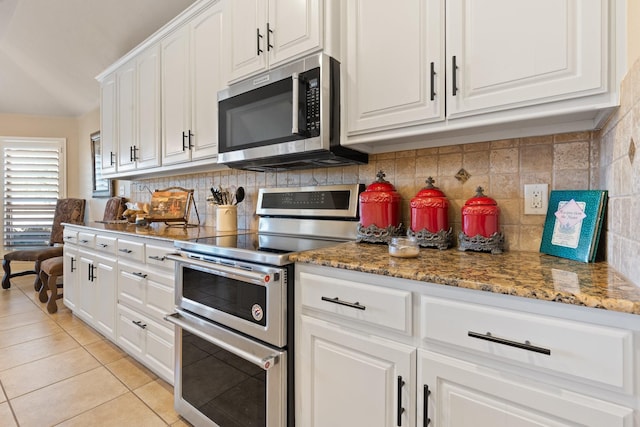 kitchen with decorative backsplash, white cabinetry, light tile patterned flooring, and appliances with stainless steel finishes