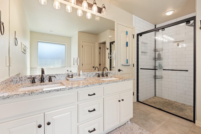 bathroom with tile patterned floors, a shower with door, and vanity