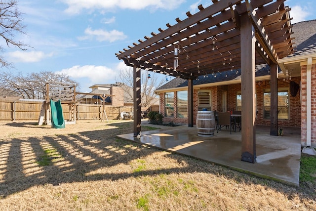 view of yard with a patio area, fence, a pergola, and a playground