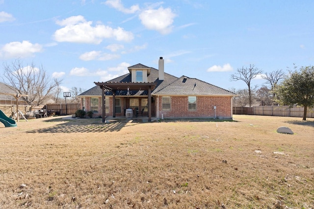 rear view of property with a fenced backyard, brick siding, a playground, and a patio