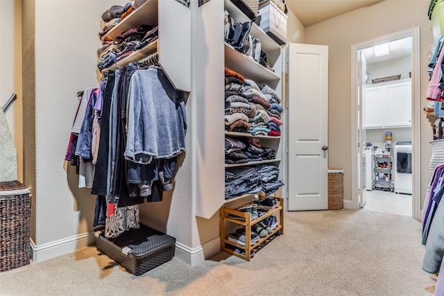 spacious closet with washing machine and clothes dryer and light carpet