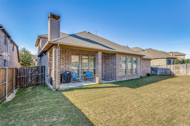 rear view of house featuring a yard and a patio