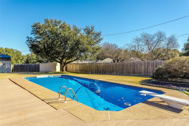 view of pool featuring a diving board and a shed