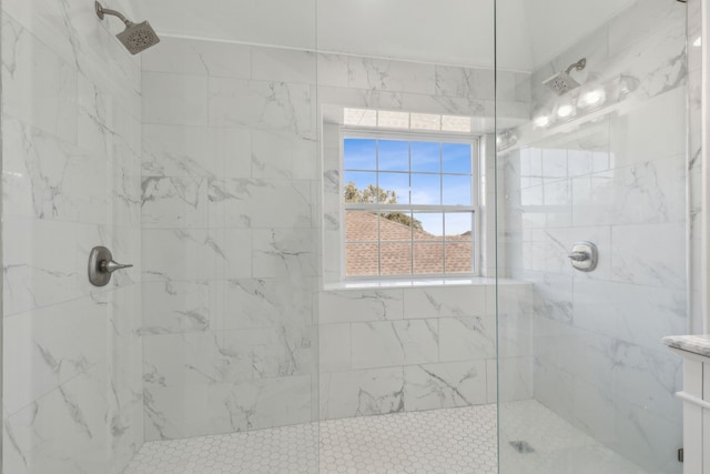 bathroom featuring tiled shower and vanity