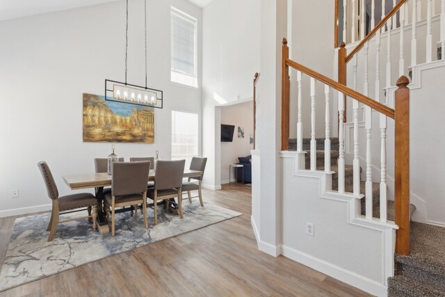 dining room featuring a notable chandelier, a high ceiling, and hardwood / wood-style flooring