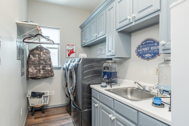 laundry area featuring washing machine and clothes dryer, cabinets, and sink