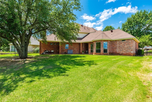 rear view of property with a yard