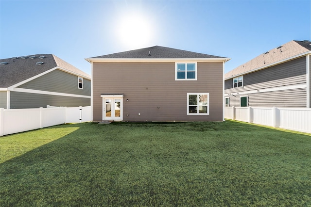 rear view of house featuring french doors and a lawn