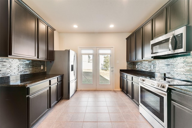 kitchen featuring backsplash, dark brown cabinets, light tile patterned floors, and stainless steel appliances