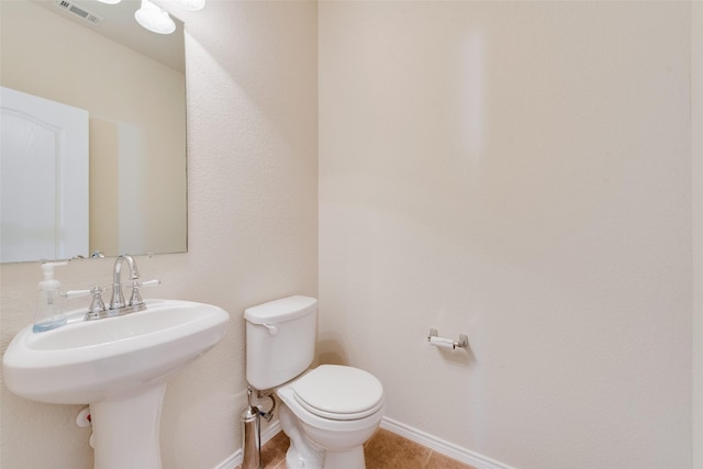 bathroom with tile patterned flooring, toilet, and sink