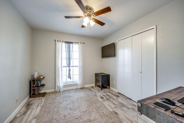 interior space with ceiling fan, a closet, and light hardwood / wood-style flooring