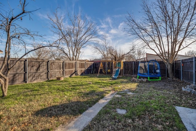 view of yard with a playground and a trampoline