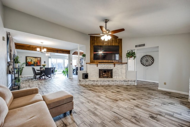 living room featuring hardwood / wood-style flooring, ceiling fan, lofted ceiling, and a fireplace