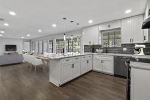 kitchen featuring white cabinets, dishwasher, kitchen peninsula, and dark wood-type flooring