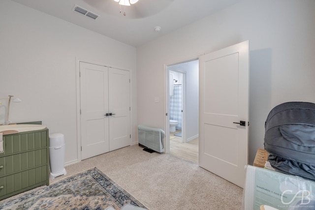 carpeted bedroom with ceiling fan, a closet, and ensuite bathroom