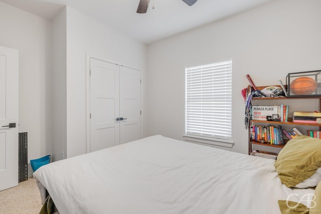 carpeted bedroom featuring ceiling fan and a closet