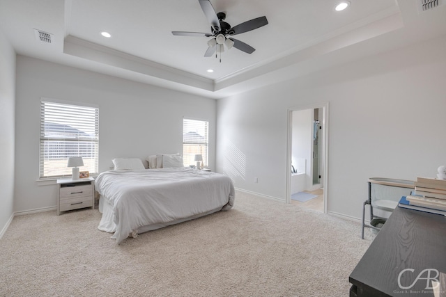 carpeted bedroom with connected bathroom, a tray ceiling, ceiling fan, and ornamental molding