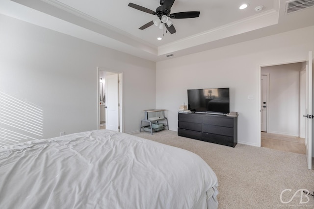 carpeted bedroom with ceiling fan, a raised ceiling, and crown molding