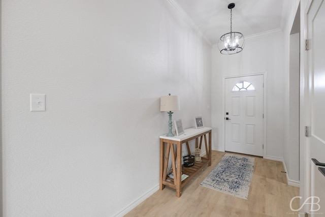 foyer with crown molding, light hardwood / wood-style floors, and a notable chandelier