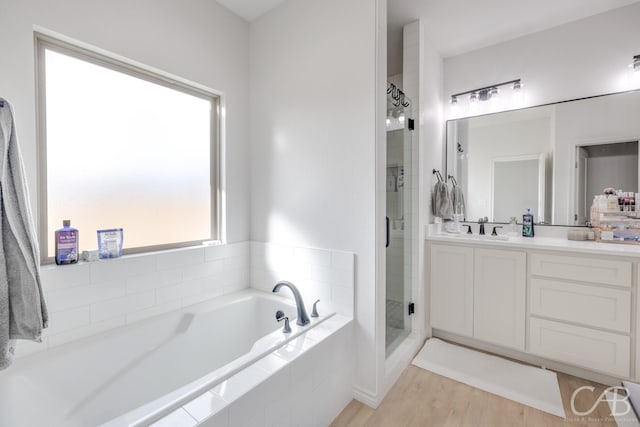 bathroom with vanity, separate shower and tub, and wood-type flooring