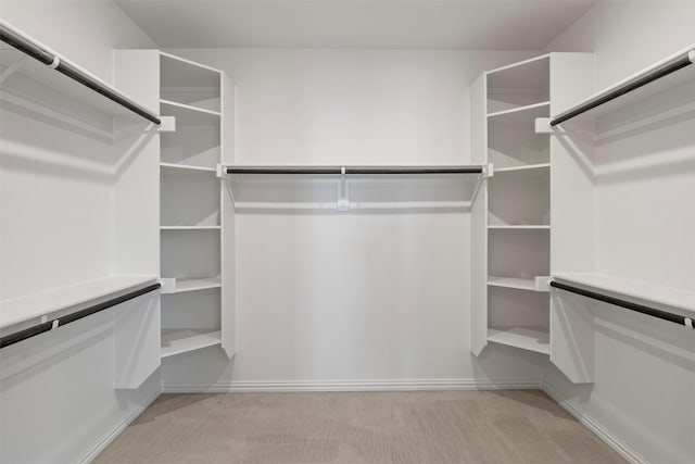 walk in closet featuring light colored carpet