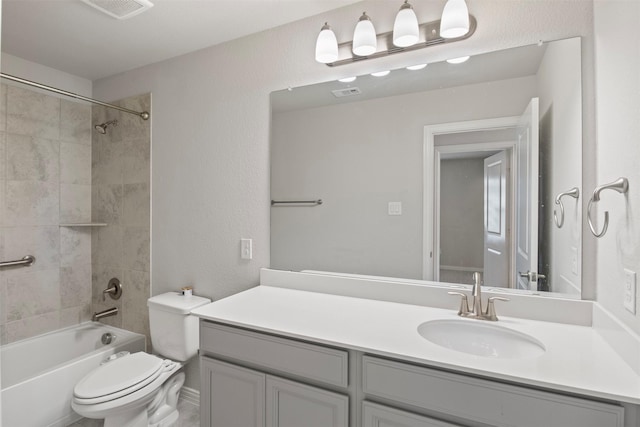 full bathroom with tiled shower / bath, vanity, and toilet