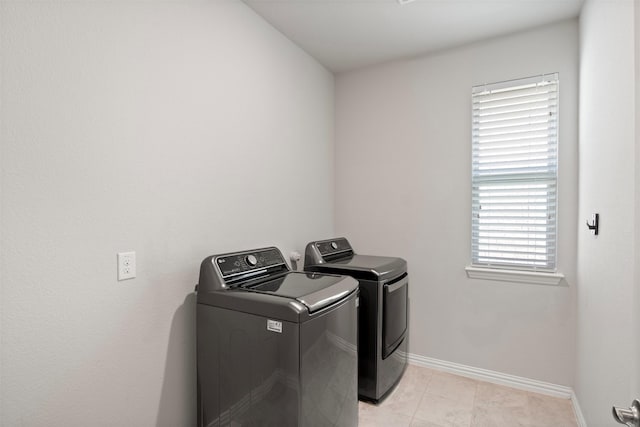 clothes washing area with light tile patterned flooring and washer and dryer