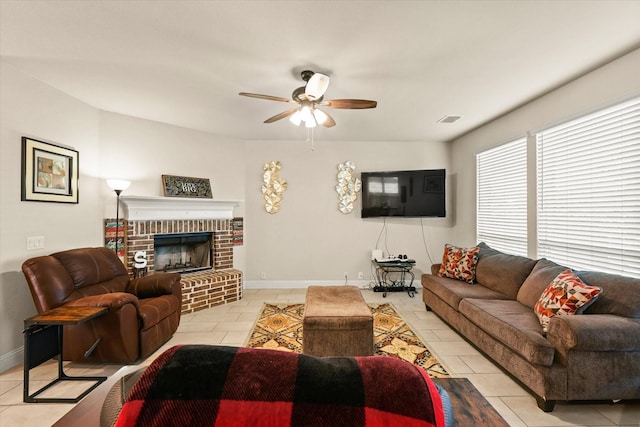 living room with ceiling fan, light tile patterned floors, and a brick fireplace