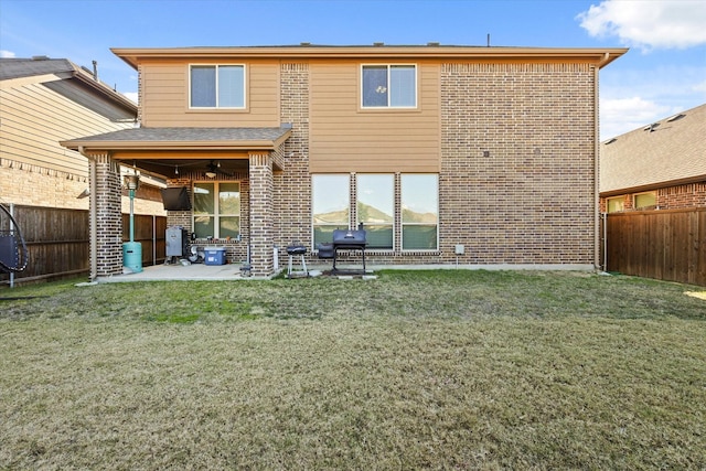 back of property with a lawn, ceiling fan, and a patio