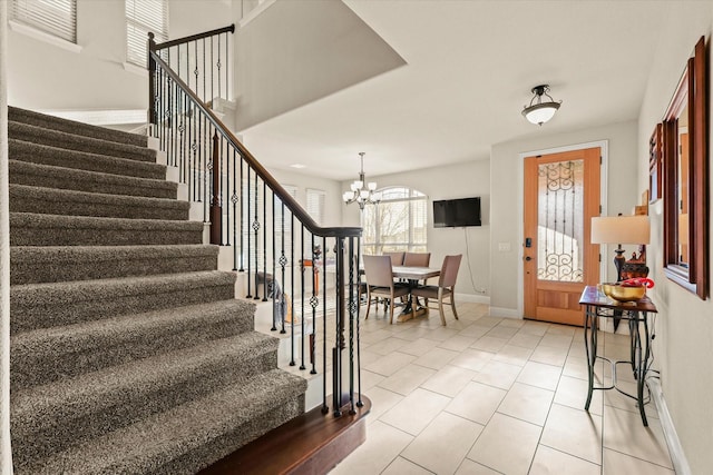 tiled entrance foyer featuring a notable chandelier