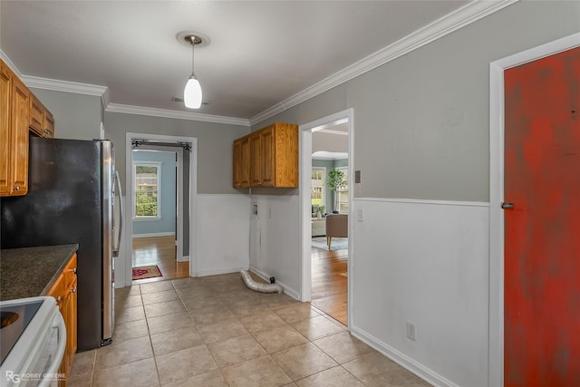 kitchen featuring pendant lighting, light tile patterned floors, crown molding, stainless steel refrigerator, and white electric stove