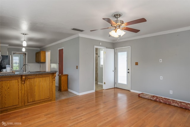 kitchen featuring sink, crown molding, fridge, light hardwood / wood-style floors, and kitchen peninsula