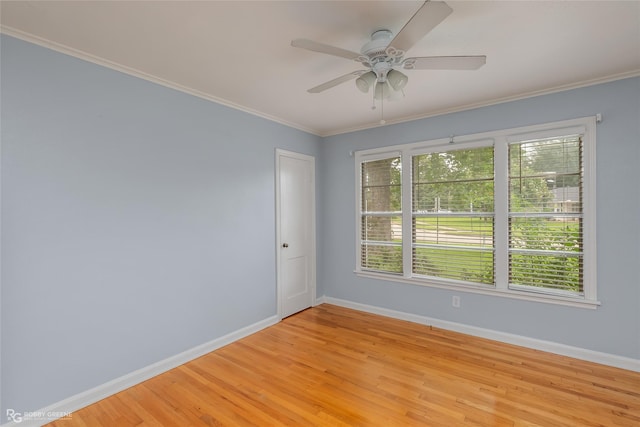 empty room featuring crown molding, a wealth of natural light, and light hardwood / wood-style flooring