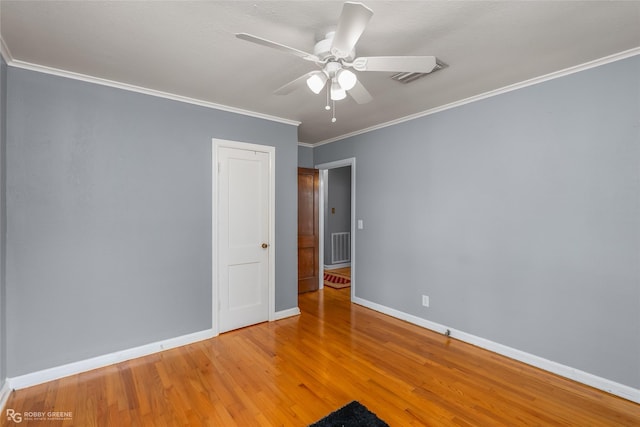 empty room with hardwood / wood-style floors, ornamental molding, and ceiling fan