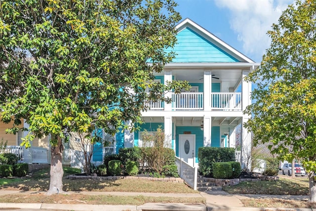 view of front of property featuring ceiling fan and a balcony