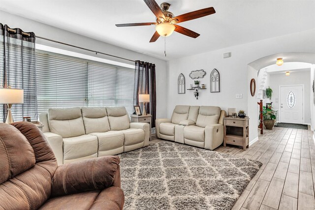 living room featuring ceiling fan and a healthy amount of sunlight