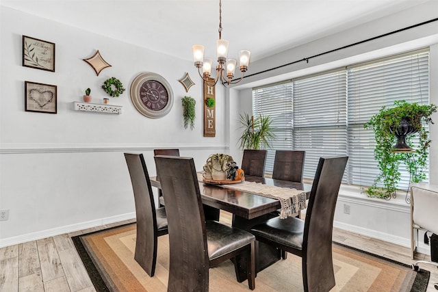 dining room with light wood-type flooring and a chandelier