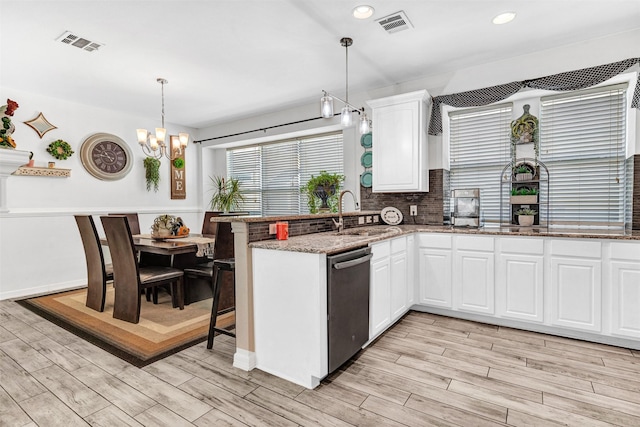 kitchen with pendant lighting, dishwasher, sink, dark stone countertops, and white cabinetry