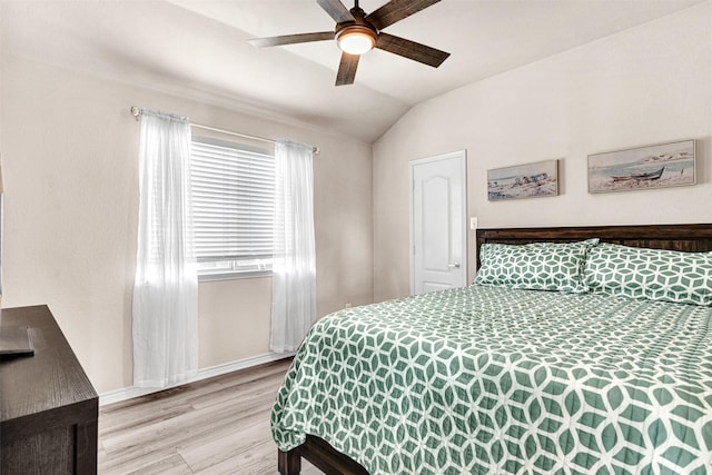 bedroom with ceiling fan, light wood-type flooring, and vaulted ceiling