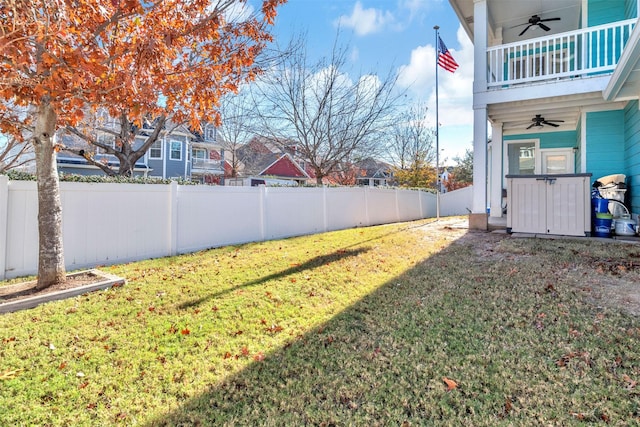 view of yard featuring ceiling fan and a balcony