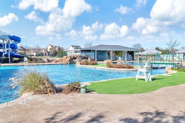 view of swimming pool featuring a patio area, a yard, and a water slide