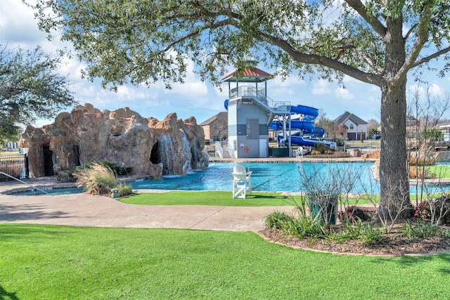 view of swimming pool with a yard