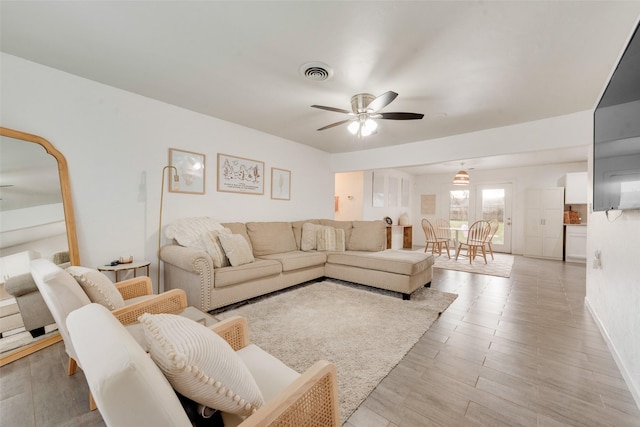 living room with light hardwood / wood-style floors and ceiling fan