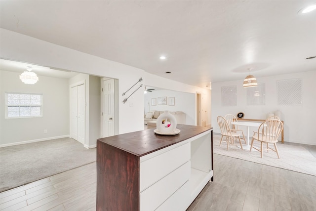 kitchen featuring pendant lighting, white cabinetry, and light wood-type flooring