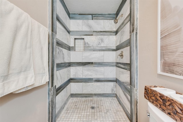 bathroom featuring toilet and a tile shower