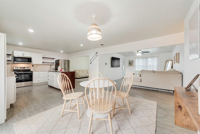 dining space with light hardwood / wood-style flooring and ceiling fan