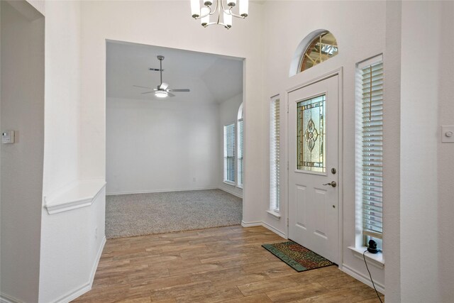 entrance foyer featuring a wealth of natural light, light hardwood / wood-style floors, and ceiling fan with notable chandelier